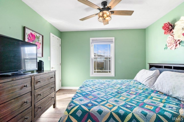 bedroom with a ceiling fan, light wood-style floors, and baseboards