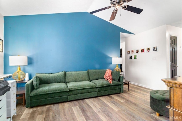 living area featuring vaulted ceiling, baseboards, a ceiling fan, and wood finished floors