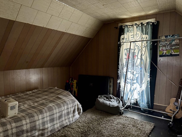 bedroom with lofted ceiling and wood walls