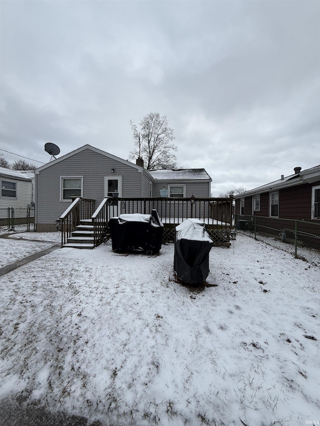 snow covered property featuring fence and a wooden deck