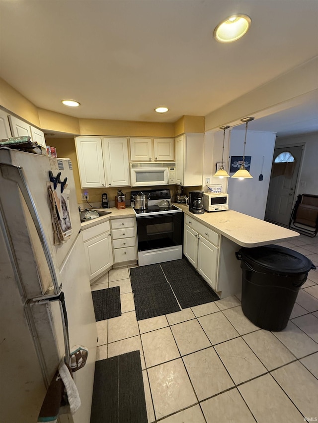 kitchen with a peninsula, white appliances, light countertops, and white cabinets