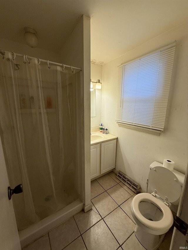 full bath featuring a stall shower, tile patterned flooring, vanity, and toilet