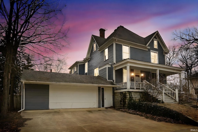 view of front facade with an attached garage, covered porch, driveway, stairway, and a chimney