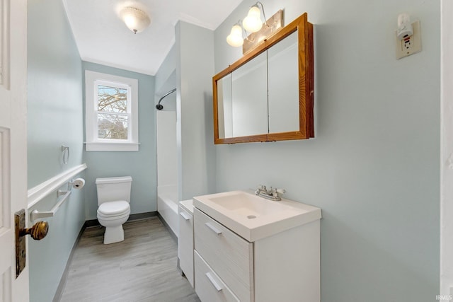 full bath with shower / bathing tub combination, toilet, vanity, wood finished floors, and baseboards