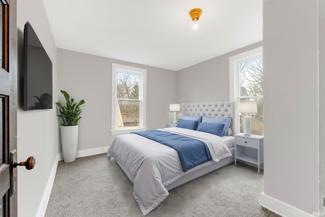 carpeted bedroom featuring multiple windows and baseboards