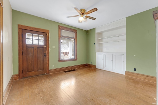 foyer with light wood-type flooring, visible vents, ceiling fan, and baseboards