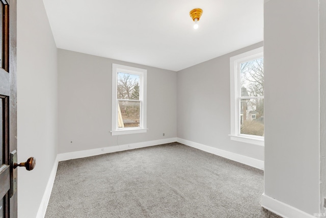 carpeted spare room with baseboards and a wealth of natural light