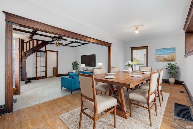 dining area with light wood-style floors, ceiling fan, stairs, and baseboards