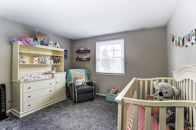 bedroom featuring a crib, dark carpet, and baseboards