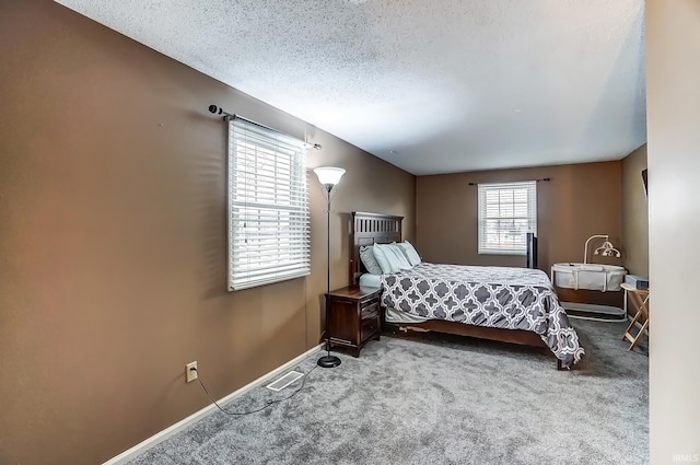 bedroom with carpet flooring, a textured ceiling, and baseboards