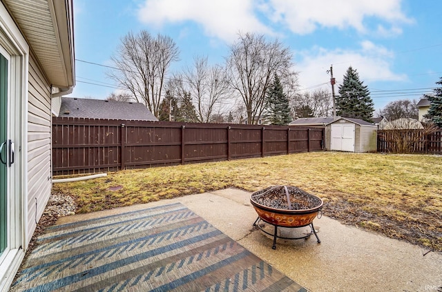 view of patio with an outdoor fire pit, a fenced backyard, an outbuilding, and a storage shed