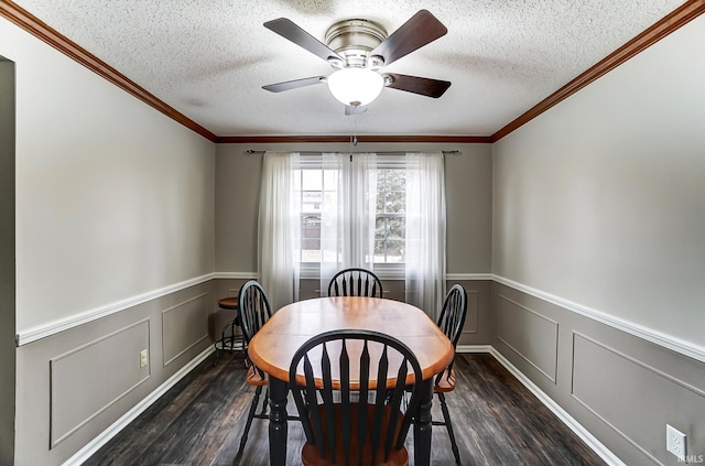 dining space featuring a wainscoted wall, a textured ceiling, and wood finished floors