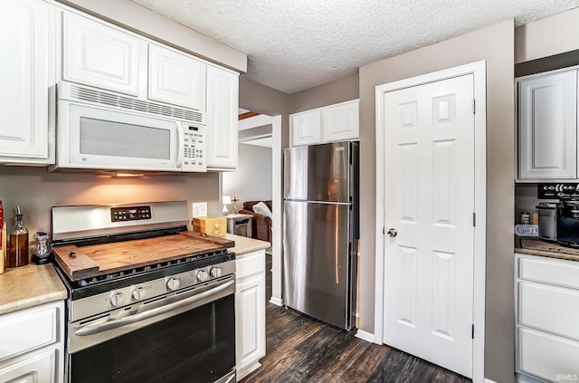 kitchen with white cabinets, appliances with stainless steel finishes, dark wood-style flooring, light countertops, and a textured ceiling