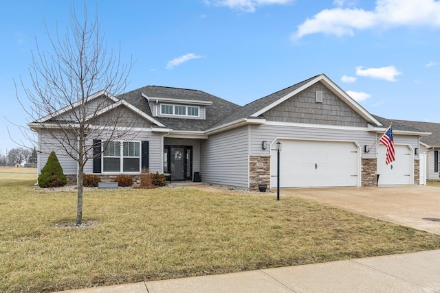 craftsman-style home with a garage, a front yard, stone siding, and driveway