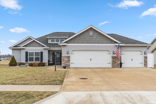 craftsman inspired home featuring driveway, a garage, and a front lawn