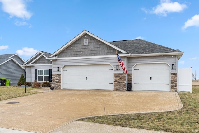 craftsman-style house featuring a garage, driveway, and roof with shingles