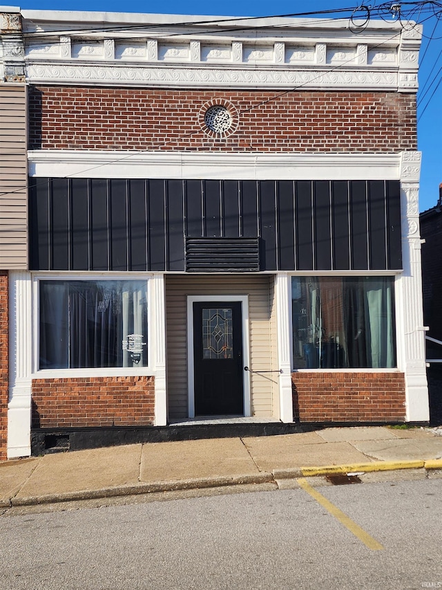 exterior space with uncovered parking and brick siding