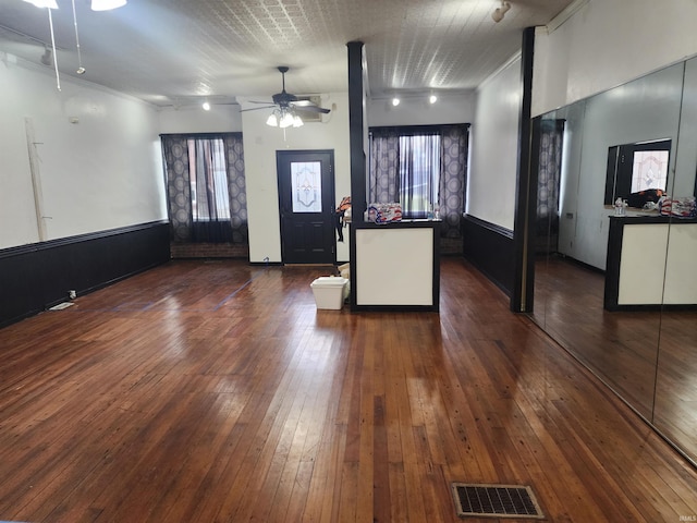 foyer entrance with ceiling fan, visible vents, a healthy amount of sunlight, wainscoting, and dark wood finished floors