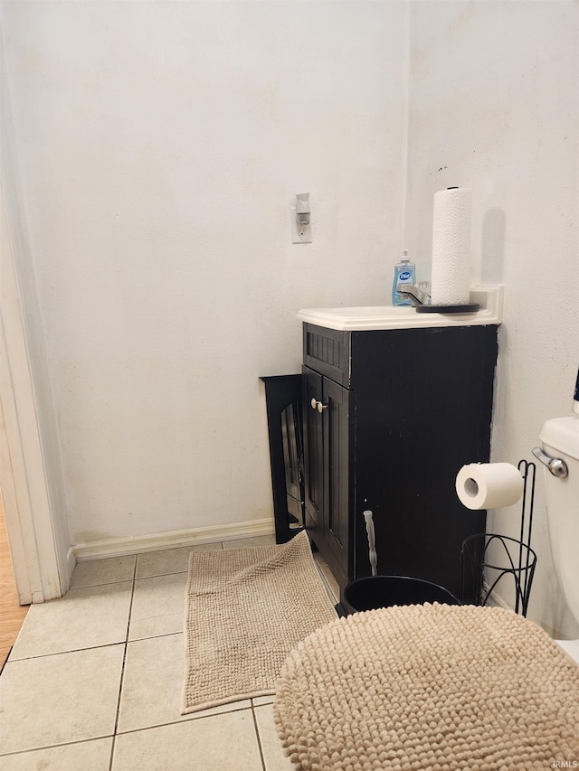 bathroom featuring tile patterned flooring, toilet, vanity, and baseboards