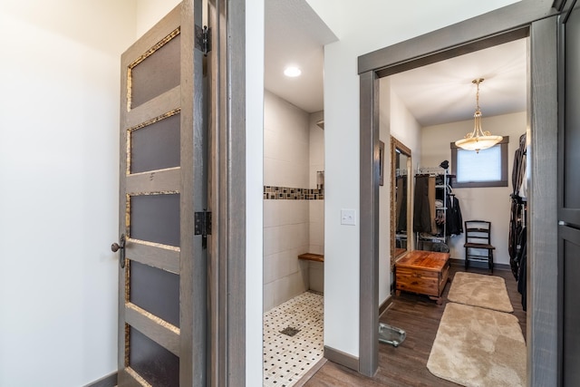 bathroom with a stall shower, baseboards, and wood finished floors