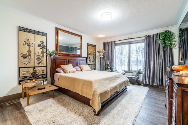 bedroom with dark wood-style floors, crown molding, and a textured ceiling