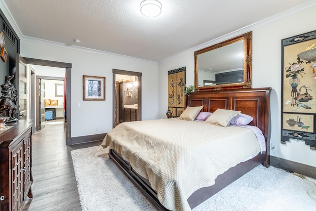 bedroom featuring crown molding, ensuite bathroom, a textured ceiling, wood finished floors, and baseboards