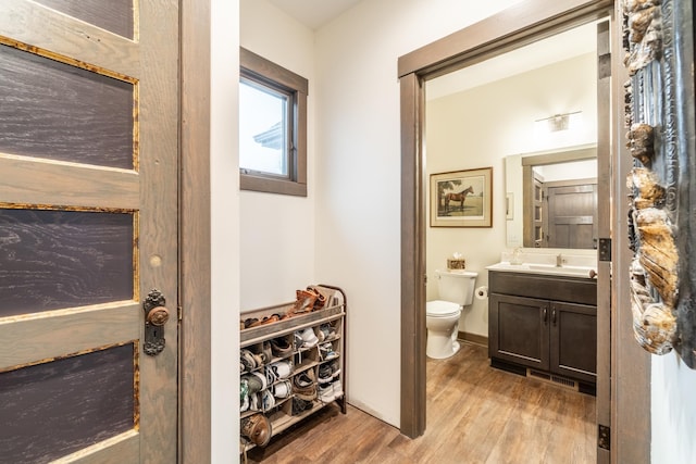 bathroom with toilet, wood finished floors, visible vents, vanity, and baseboards