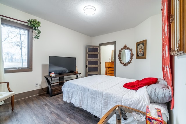 bedroom featuring a textured ceiling, dark wood-type flooring, and baseboards