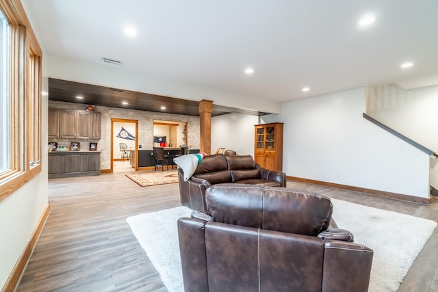 living room featuring light wood-style flooring, visible vents, baseboards, and recessed lighting