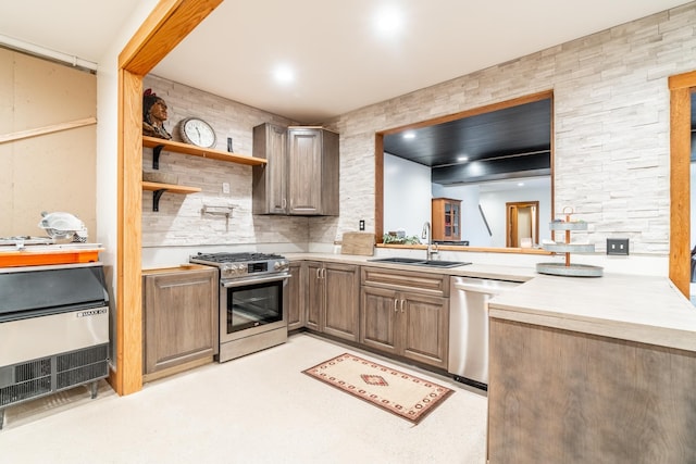 kitchen with appliances with stainless steel finishes, light countertops, and a sink