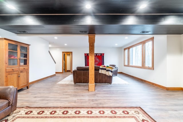 living room with light wood finished floors, recessed lighting, baseboards, and ornate columns