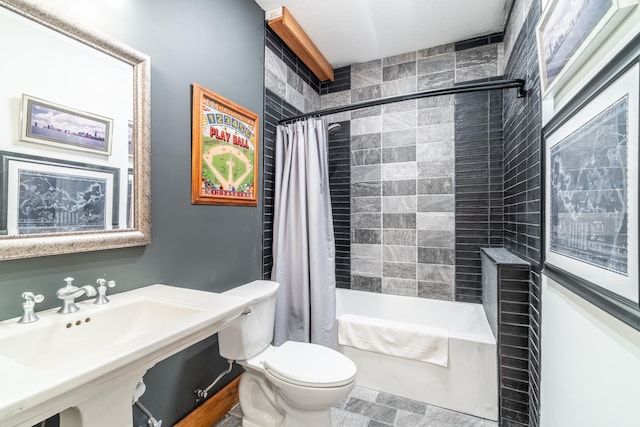 bathroom featuring toilet, shower / bath combination with curtain, and a sink