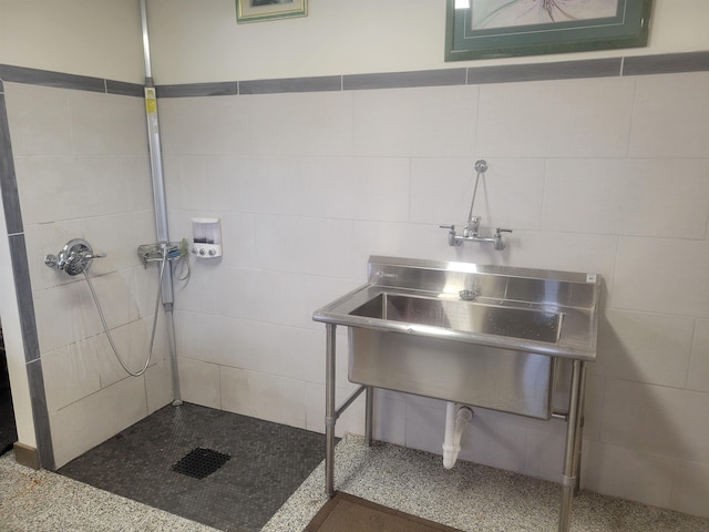 full bath featuring a sink, tile walls, and tiled shower