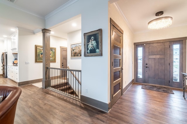 foyer entrance with ornamental molding, ornate columns, baseboards, and wood finished floors