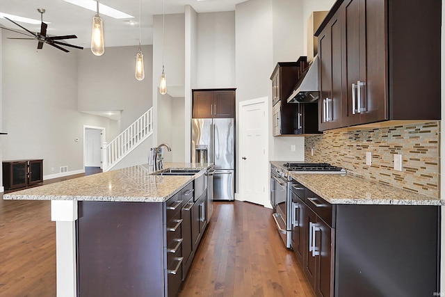 kitchen with dark wood-style floors, stainless steel appliances, a sink, dark brown cabinets, and ventilation hood