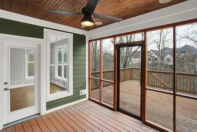 unfurnished sunroom with wood ceiling and a ceiling fan