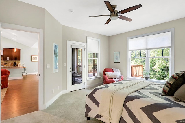 bedroom with lofted ceiling, access to outside, multiple windows, and baseboards