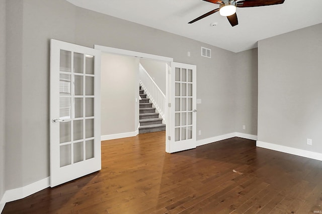 spare room with baseboards, visible vents, hardwood / wood-style flooring, stairs, and french doors