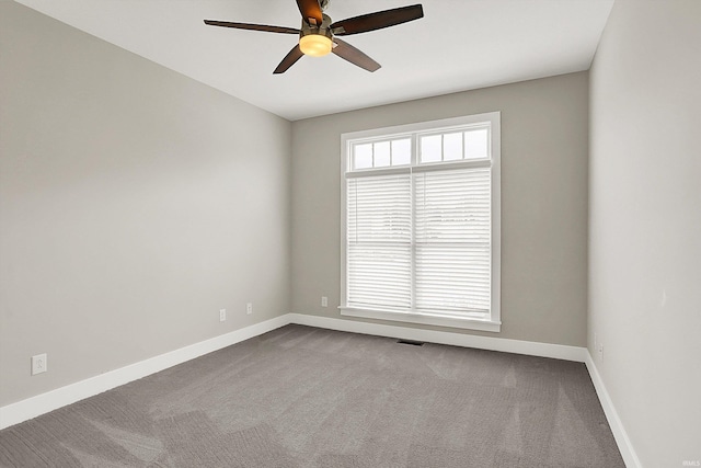 carpeted empty room with a ceiling fan, visible vents, and baseboards