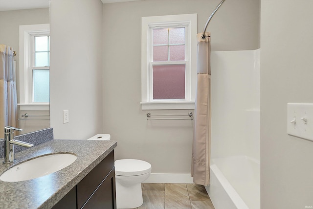 bathroom featuring toilet, baseboards, and vanity