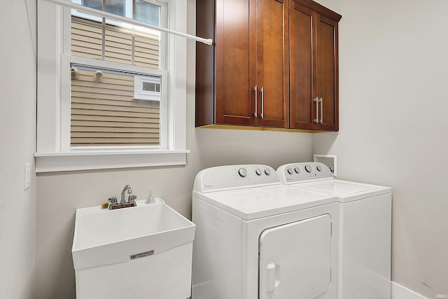 clothes washing area featuring cabinet space, washer and clothes dryer, and a sink