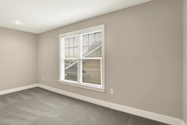 unfurnished room with baseboards, dark carpet, and recessed lighting