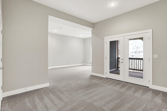 spare room with french doors, carpet, recessed lighting, and baseboards