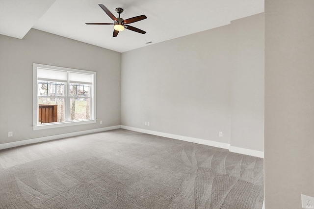 carpeted spare room featuring a ceiling fan, visible vents, and baseboards