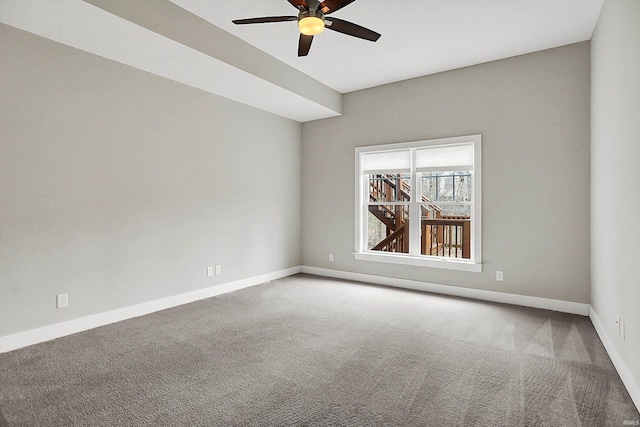 spare room with carpet flooring, a ceiling fan, and baseboards