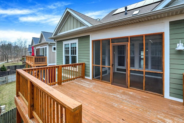 wooden terrace featuring a sunroom and fence