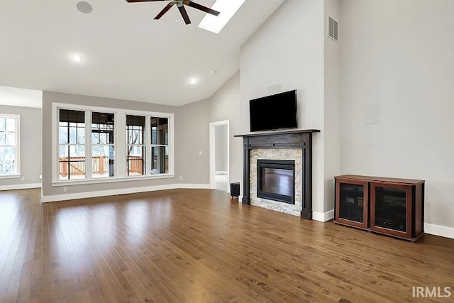 unfurnished living room with a fireplace, wood finished floors, visible vents, and a ceiling fan