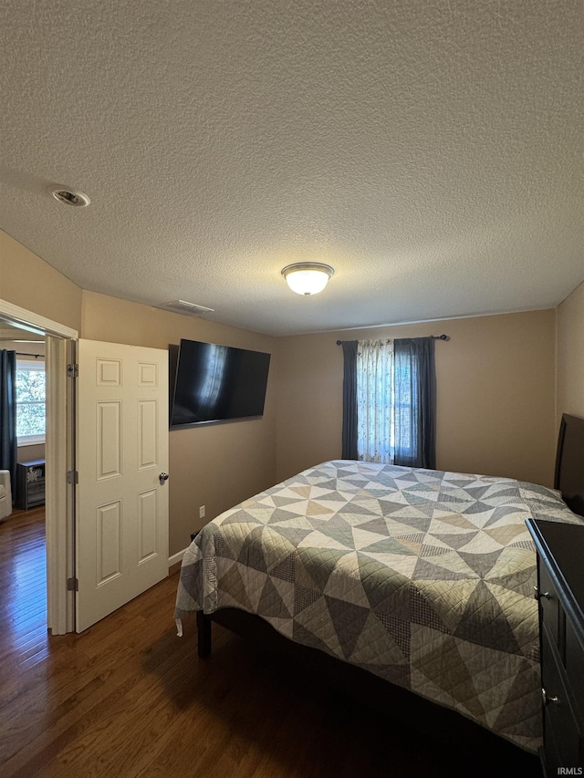 bedroom featuring a textured ceiling and wood finished floors