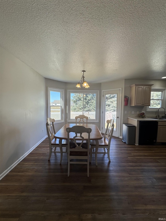 dining space featuring a textured ceiling, dark wood-style flooring, and baseboards