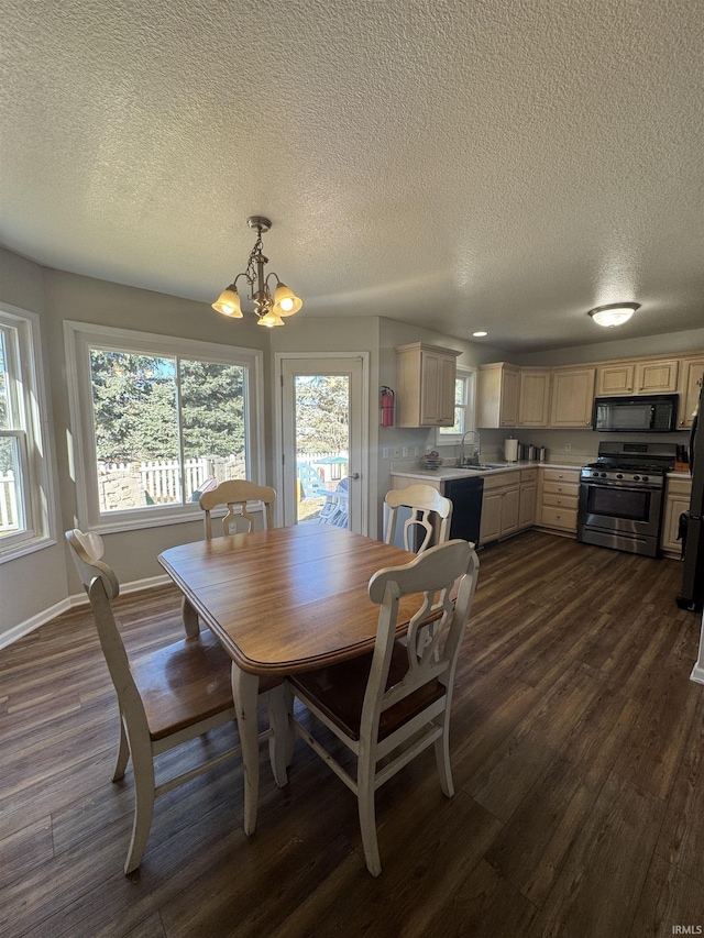 dining area featuring a chandelier, dark wood-type flooring, a textured ceiling, and baseboards